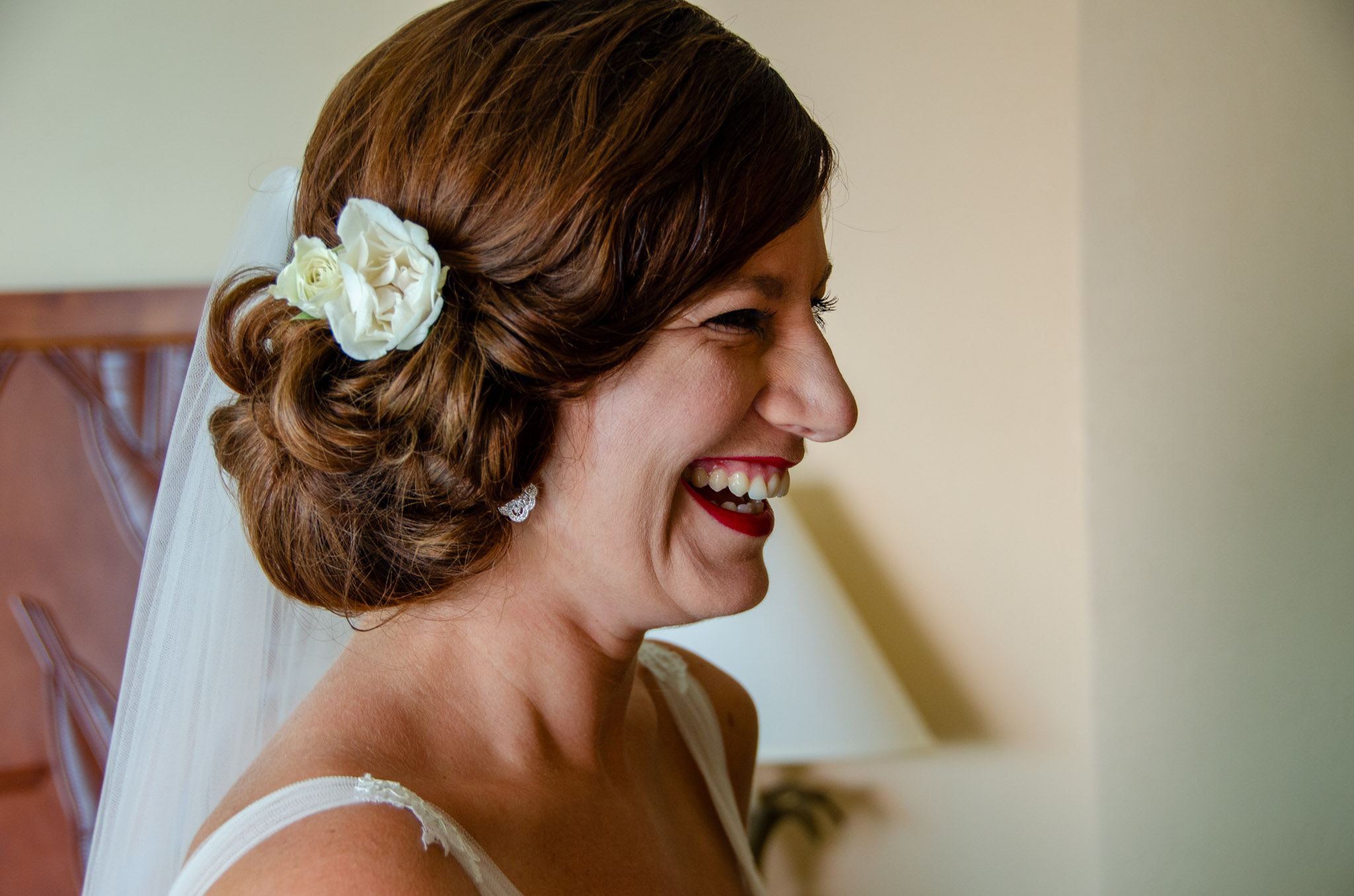 Bride laughing with a white flower in her hair